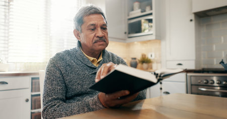 Reading, prayer and bible with old man in kitchen for worship, spiritual or Christian religion....