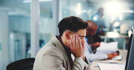 Business, stress and man in office with headache, pressure and exhausted accountant on deadline. Migraine, tired and employee on computer with fatigue, burnout and financial mistake or fail at nightの写真素材