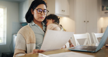 Woman, reading document and baby at house for multitasking, budget and bank loan. Busy, person and laptop with child sleep for finance paperwork, bills payment and account invoice of mortgage balanceの写真素材