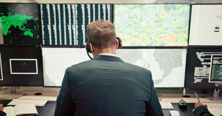 Headset, back or man with screen for maps for news, research or ecology in data center. Pattern, check or computer for tracking technology for meteorology info, storm radar or climate change forecastの写真素材