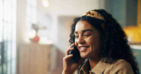 Home, phone call and woman with smile, conversation and communication with positive news. Apartment, happy person or girl in lounge, smartphone or mobile user with digital app for chatting or contactの写真素材