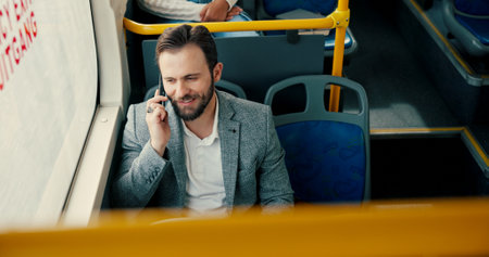 Business, commute and phone call with man on bus for communication or public transport to work. Conversation, journey and travel with happy employee in vehicle for trip as passenger from aboveの写真素材