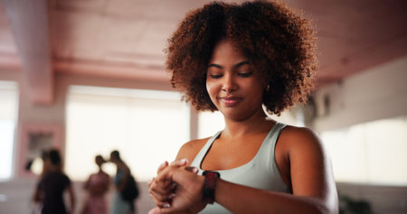 Fitness, smart watch and woman in gym, check progress for exercise goals and cardio stats. African person, workout or athlete in health center, app for heart monitor or training with results or prideの写真素材