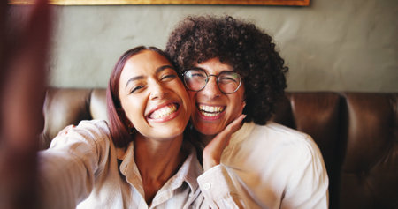 Love, POV and selfie with couple in coffee shop together for bonding, memories or romance. Dating, profile picture or social media post with happy man and woman in booth of cafe or restaurantの写真素材