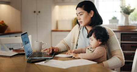 Home, toddler and mom with laptop, remote work and bookkeeper with paperwork in kitchen, family or online. Multitasking, mother and care for baby in house, accountant and person with tech for projectの写真素材