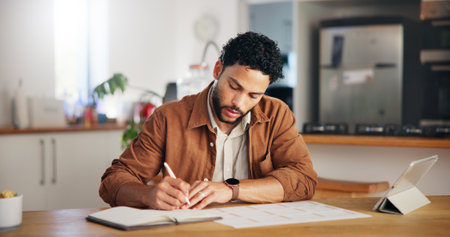 Man, writing and calendar planning in home with tablet agenda, priority checklist and time management. Remote work, entrepreneur or schedule for tasks reminder, appointment update or notes in kitchenの写真素材