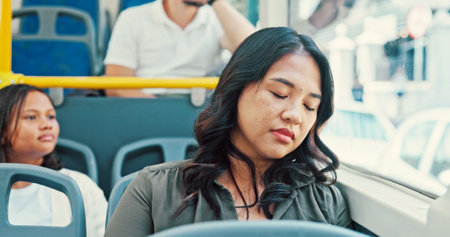 Bus, sleeping and woman with rest, travel and break with public transportation. People, commute and girl with fatigue, tired and exhausted with burnout, overworked and window with urban journeyの写真素材