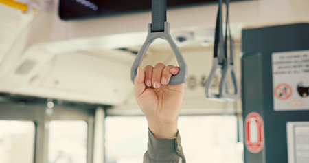 Hand, bus and safety with person, handle and travel with public transportation. Closeup, metro and passenger with routine, urban journey and morning commute with city service, trip and New Yorkの写真素材