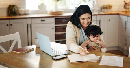 Smile, woman and writing with baby in house for financial planner, schedule update and payment reminder. Person, notebook and laptop with child for information ideas, bills checklist and multitaskingの写真素材