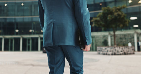 City, walking and back of business man on morning commute, journey and travel to office. Professional, corporate worker and person with tablet in urban town for work trip, job and career outdoorsの写真素材