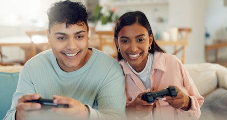 Playful, smile and gaming with couple on sofa for esports challenge, arcade and competition. Happiness, streaming and contest with man and woman in living room at home with gamer controller and funの写真素材