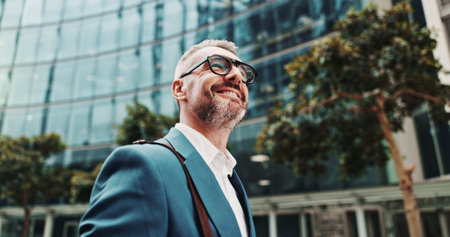 Business, smile and man in city, below and ideas with wonder, thinking and commute. Mature person, financial advisor or consultant in street, excited and contemplation with decision, choice or travelの写真素材