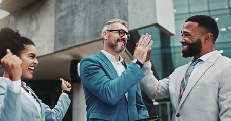 Business people, high five and happy in city, group and support with deal for urban real estate sale. Men, woman and excited with goals, motivation and achievement for property development agencyの写真素材