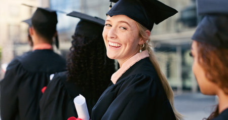 Graduate, ceremony or portrait of happy woman at university for education, school or success. Queue, graduation or confident student in line at campus with knowledge, smile or college achievementの写真素材