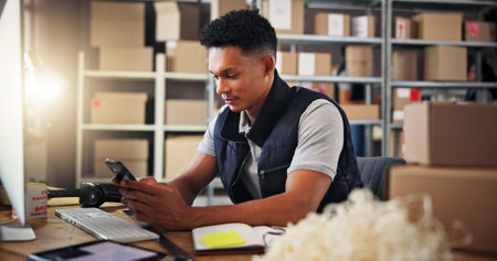 Warehouse, shipping and man with phone in office for delivery, supply chain and retail production. Ecommerce, distribution and person on smartphone with boxes for manufacturing, logistics and contactの写真素材