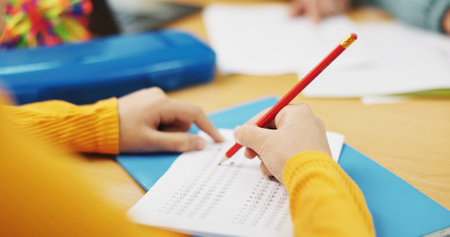 Education, student and hands with test answer for multiple choice assessment, academic evaluation or exam. Classroom, person and writing school questionnaire for scholarship, knowledge or quiz optionの写真素材