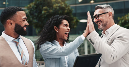 High five, happy and people with tablet, business and real estate agent with tech for collaboration. Success, colleagues and group with website for property, info and celebration for market trendsの写真素材