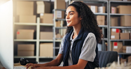 Small business, logistics and woman with computer for inventory, checking stock or research online. Office, female person and supply chain manager with tech to monitor distribution, order or deliveryの写真素材