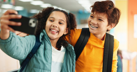 School, hallway and selfie of children with smile for studying, classroom and learning. Students, campus and kids in corridor with profile picture for education, social media and memory in morningの写真素材
