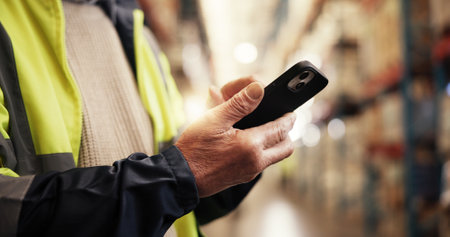 Hands, phone and contact at warehouse, logistics and update shipping schedule for export delivery. Person, engineer and smartphone with mobile app for freight, storage and stock at industrial plantの写真素材