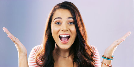 Woman, wow and shock in studio portrait for announcement, deal and good news by background. Girl, excited and smile with surprise, open hands and shouting for discount sale with space in Argentinaの写真素材