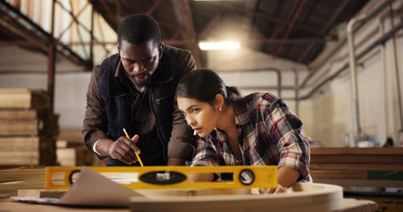 Measure, teamwork and carpenter with people for woodworking production, furniture and manufacturing. Collaboration, handyman and framework with man and woman for building project and constructionの写真素材