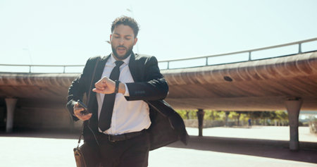 Outdoor, businessman and rush with watch for time, morning commute and late for justice meeting. Clock, male lawyer and travel in hurry for case schedule, urgent deadline and running with smartphoneの写真素材