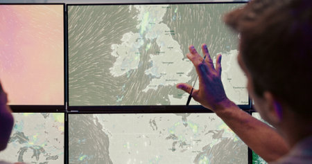 Screen, weather and man with wind discussion for news, research and reporter. Presenter, ecology conversation and professionals with forecast on media report for meteorology update for climate changeの写真素材