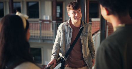 Boy, students and talking in hallway at high school for education break, campus gossip or scholarship discussion. Friends, people and happy with conversation at academy for learning recess and relaxの写真素材