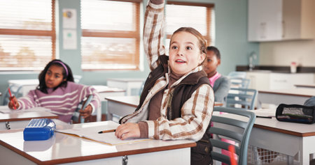 Girl, raised hand and education in classroom, smile or excited with answer, quiz or development at school. Kids, pupil and happy for solution, question or test for assessment with learning at academyの写真素材