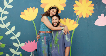 Hug, wall and portrait of couple for painting, creative project and decoration outdoors. Happy, smile and man and woman with inspiration for flowers, spring aesthetic and DIY art for community centreの写真素材
