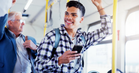 Happy man, student and bus with phone for public transport, travel app or local commute in city. Male person, smile and tourism with mobile smartphone in vehicle for road trip, journey or destinationの写真素材