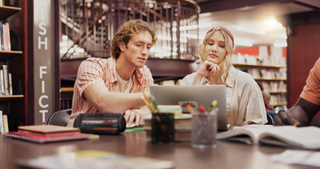 Students, man and woman with laptop at library for group project, research and education at...