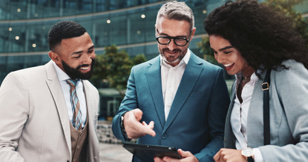 City, employees and people with tablet, outdoor and real estate agent with collaboration for business. Teamwork, colleagues and group with website for property, info and discussion for market trendsの写真素材
