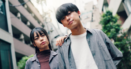 Japanese couple, portrait and fashion in city with confidence on travel, attitude and summer in street. Man, woman and together with partner, love or bonding for connection in low angle on urban roadの写真素材