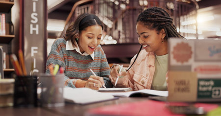 Students, women and friends with notebook at library for group project, research or education at university. People, girl and review with problem solving, notes or learning for scholarship at collegeの写真素材