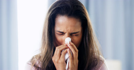 Sick, bed and woman blowing nose for allergies, hayfever or sneeze with recovery in home. Health,...