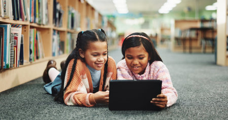 Students, library and girls on floor, tablet and online learning with education, smile and relax....