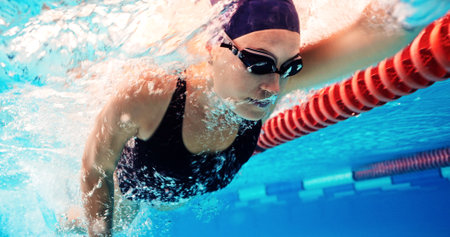 Swimming, training and athlete in pool, water and practice for competition, healthy and workout in morning. Sports, active and person with energy for performance, exercise and swimmer with routineの写真素材