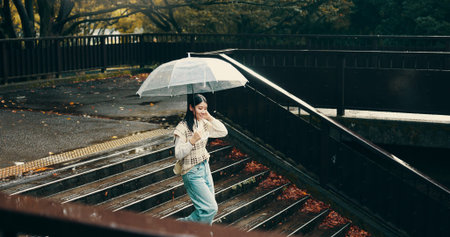 Umbrella, stairs and woman in city walking in rain on vacation for exploring, adventure or fun....