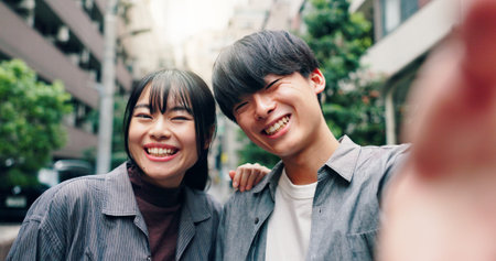 Happy, asian couple and portrait with selfie for picture, photography or memory together in city street. Japanese, man and woman with smile for moment, capture or bonding in an urban town in Tokyoの写真素材
