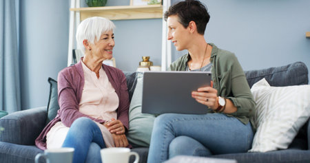 Tablet, teaching and woman with senior mom on sofa for chatting, scrolling or networking. Digital...