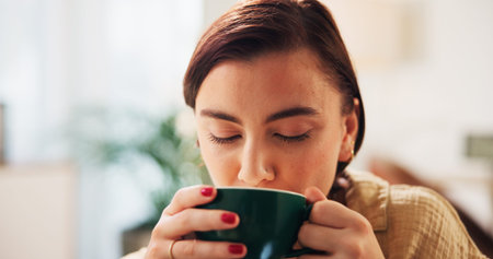 Coffee, relax and woman in home with drink for caffeine beverage or cappuccino in morning. House,...