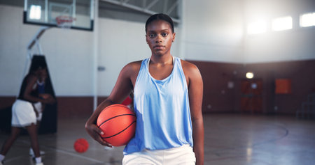 Portrait, player or serious black woman with basketball for sports, fitness, and confidence at gym. Girl, court or athlete in practice with hobby or pride for contest, workout challenge and exerciseの写真素材