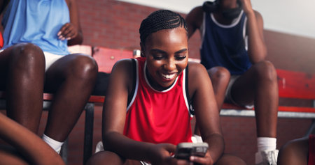 Phone, smile and search with black woman on basketball court for sports progress, athlete scouting and contact. Score tracking, training program and hoop metrics with person and game updatesの写真素材