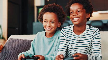 Video games, happy and children on sofa in home for competition, winning and playing online in...