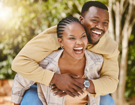 Couple, piggyback and happy in nature for love, care and relationship with partner, fun and bonding. Man, woman and smile for embrace, support and joyful with commitment, loyalty and playful dateの写真素材
