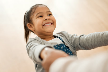 Parent, daughter and holding hands in dance in home together with love, bonding and care with smile. Family. dancer and guardian with girl child in living room for movement, celebration or happinessの写真素材