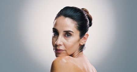 Beauty, portrait and shoulder of woman in studio for antiaging treatment or wellness routine. Cosmetics, dermatology and skincare with mature model on gray background space for facial transformationの写真素材