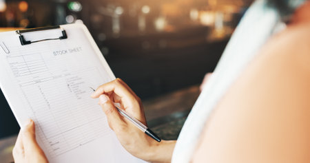 Person, hands and writing with checklist at cafe for stock sheet, inventory or catering service. Closeup, small business owner or manager with inspection or notes for order or products at coffee shopの写真素材